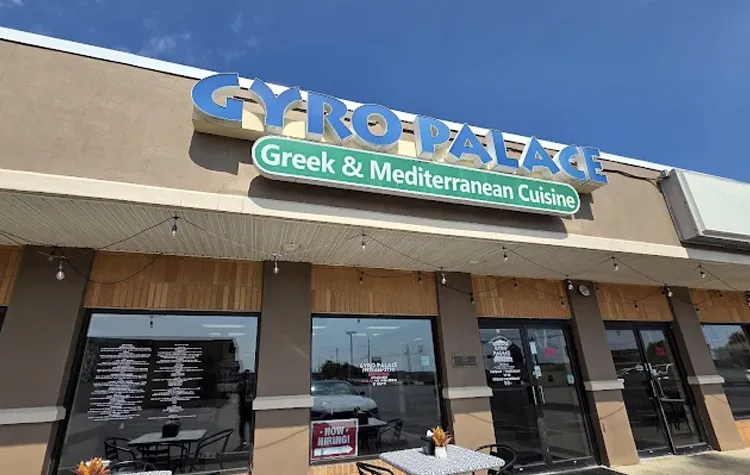 Gyro Palace Greek & Mediterranean Cuisine restaurant storefront with a blue sign and glass doors.