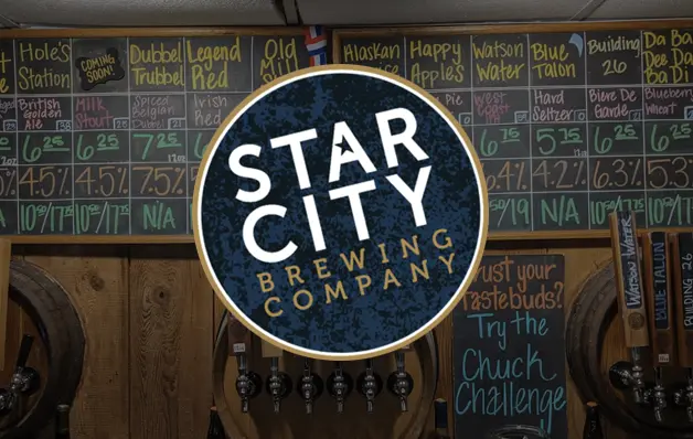 Circular Star City Brewing Company logo on a bar wall with chalkboard menus behind it.