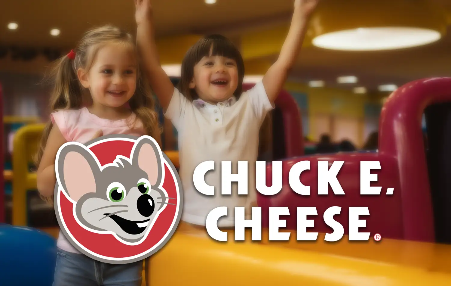 Two smiling kids in a bright Chuck E. Cheese play area with the Chuck E. Cheese logo visible.