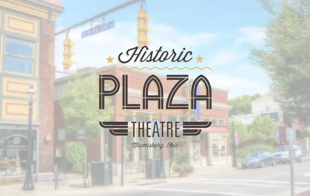 Bright street scene with brick storefronts, trees, and a large decorative sign reading "Historic Plaza Theatre."