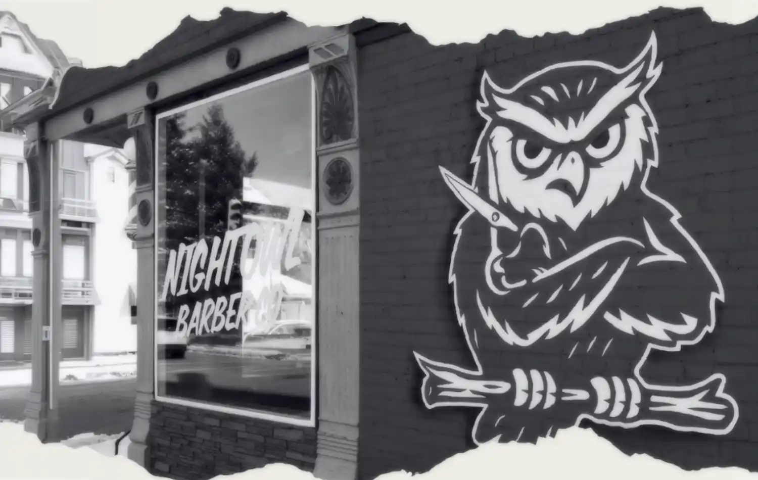 Night Owl Barber Co. Graffiti mural of a large white owl perched on a branch on the side of a building beside a storefront window.
